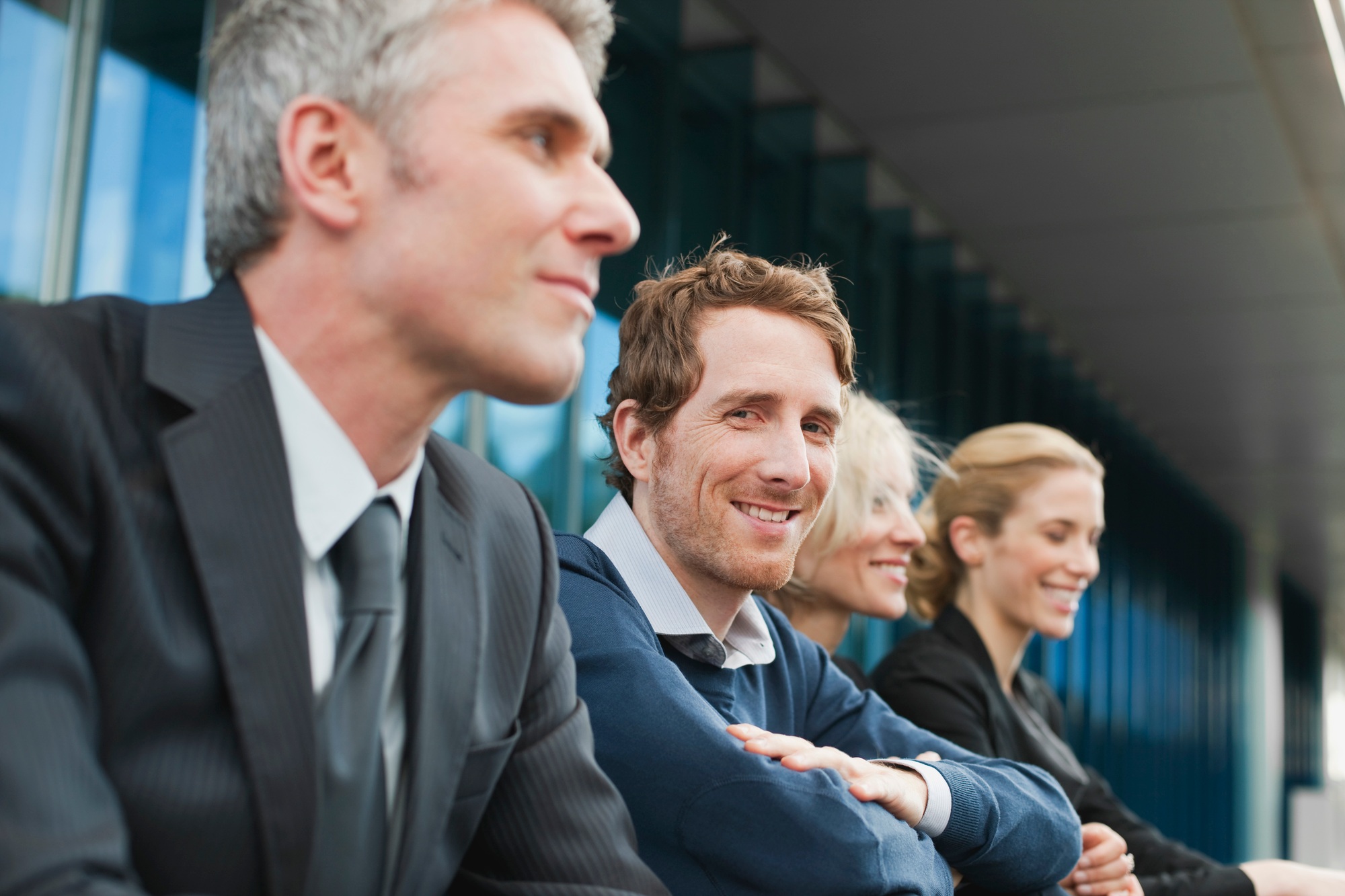 Germany, Hamburg, Four Business people sitting on steps in front of office building
